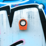 Pomarańczowy obiektyw na kolorowym graffiti