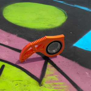 Pomarańczowy przedmiot na kolorowym tle ulicznym.