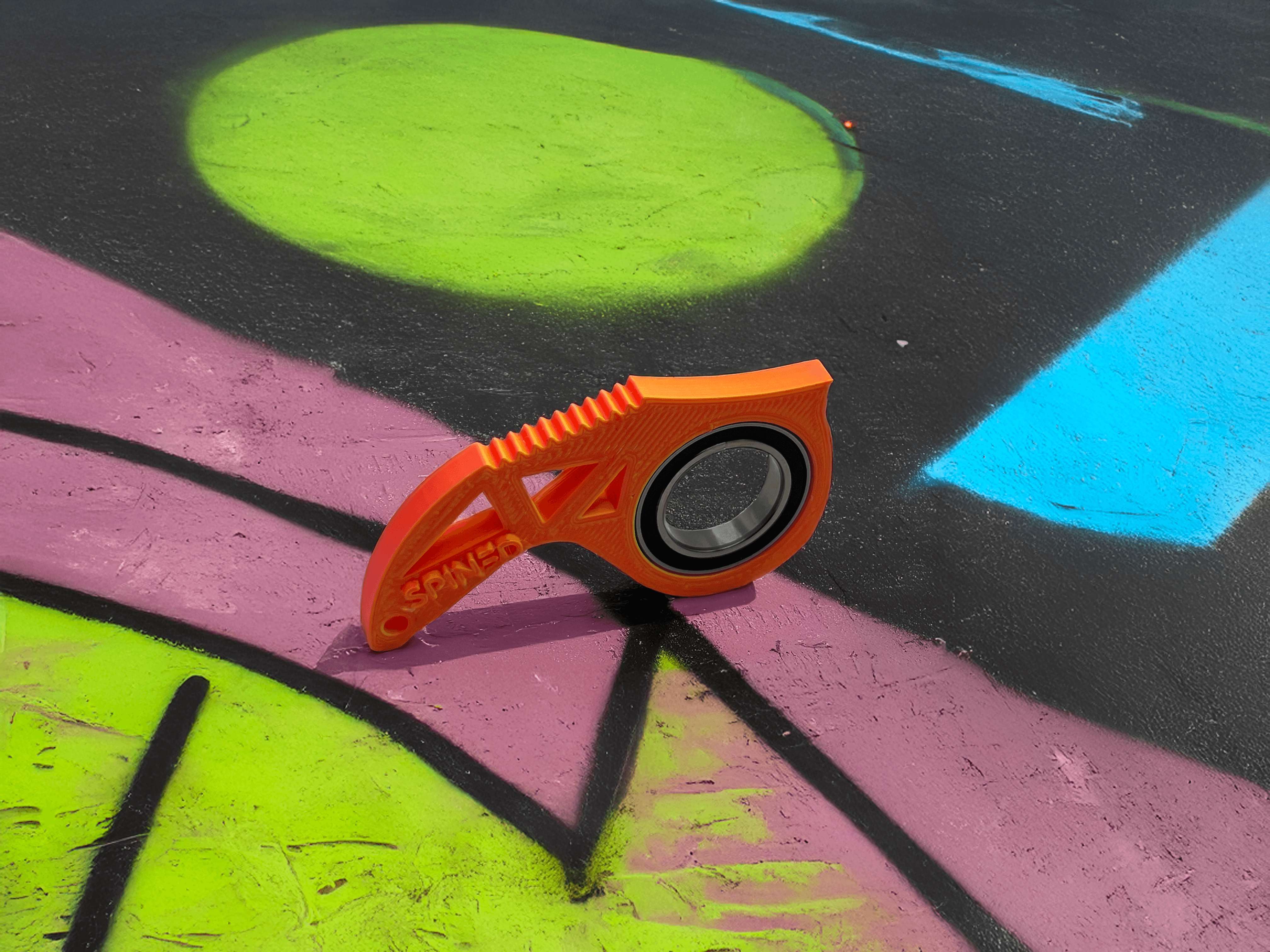 Pomarańczowy przedmiot na kolorowym tle ulicznym.