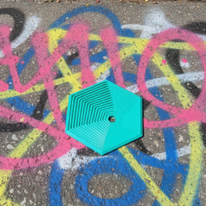 Graffiti na chodniku z turkusowym obiektem